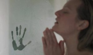 L'actrice Elisabeth Moss interprète Cecilia sous la douche, qui ne remarque pas une étrange emprinte de main d'homme marquée dans la buée, scène du film Invisible Man pour notre article sur les femmes dans le cinéma de genre.