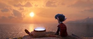 Ian est assis avec les jambes de son père, sur une falaise donnant vue sur la mer et le soleil couchant, scène du film En avant de Pixar.