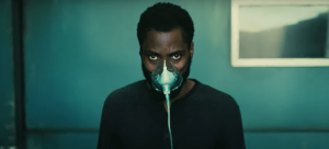 John David Washington est assis avec un masque à oxygène sur le visage dans le film Tenet un des blockubusters 2020.