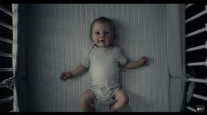 Contre-plongée sur un bébé qui semble factice dans un berceau ; plan de la série Servant saison 2.