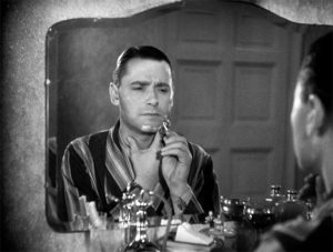 Herbert Marshall se rase devant le miroir, la mine songeuse et triste dans le film Meurtre de Alfred Hitchcock.