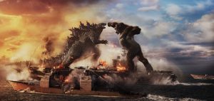 Godzilla vs. Kong se battent en pleine mer, à côté d'un large bateau de conteneurs.