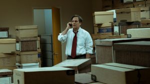 Mark Ruffalo au téléphone au milieu de nombreux cartons dans une salle d'archive, personnage anti-système symptomatique du cinéma de genre sous Donald Trump.