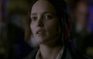 Plan rapproché-épaule sur Rebecca Breeds, qui regarde l'horizon, de nuit, le regard interrogateur et flottant ; plan issu du film Clarice.