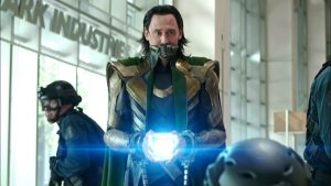Dans le hall d'entrée de Stark Industries, Loki tient le tesseract bleu entre ses mains, qui luit.
