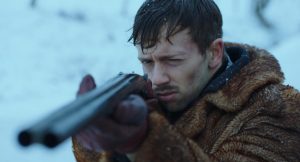Un jeune homme dans un paysage de neige, vise avec un fusil de chasse dans le film de fin d'études de Baptiste Drapeau.
