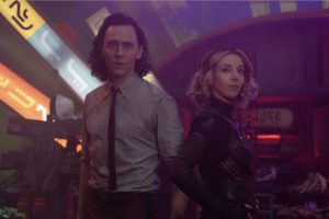 Loki et Sylvie posent devant un fond futuriste, avec des néons contenant des idéogrammes ; tous deux regardent l'objectif.