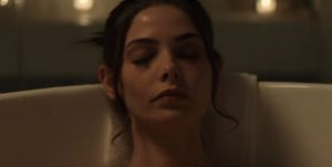 Ashley Greene Khoury est dans sa baignoire, les yeux clos dans une lumière tamisée ; scène du film Aftermath.