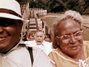 Dans les montages russes, un couple de vieux afro-américains tout sourire, entre eux, nous voyons un vieillard terrorisé ; scène du film The Amusement Park.