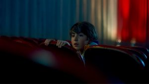 Un petit garçon se cache derrière un siège de salle de cinéma dans le film Al morir la matinée.