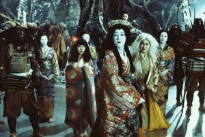 La princesse Shirayuki lancée dans l'évocation de son amoureux, devant toute sa cour d'êtres fantastiques : fantômes de samouraïs, servantes pâles, dans le film L'étang du démon.