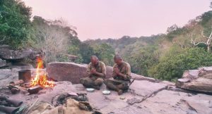 Sur un flanc de colline donnant sur la jungle, Onoda et son collègue mangent à quelques mètres d'un feu improvisé dans le film de Arthur Harari.