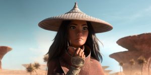 Raya regarde vers l'horizon, en plein désert secoué par le vent ; plan issu du film Raya et le dernier dragon pour notre article sur les films Disney 2021.