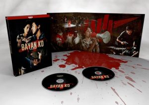Coffret du film Bayan Ko, ouvert pour présenter l'artwork intérieur contenant les disques et des images du film, édité par Le Chat qui Fume.