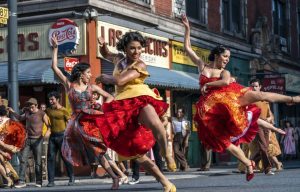 Trois femmes en robes flamboyantes livrent un flamenco énergique en pleine rue dans le film West Side Story 2021.