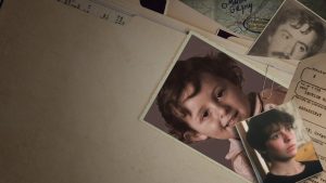 Des photos du petit Gregory et de ses deux parents sont posés sur un dossier, sur une table dans le documentaire true crime Gregory de Netflix.