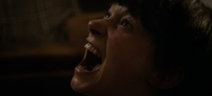 Gros plan sur le visage d'une femme qui hurle d'effroi, les yeux dirigés vers le plafond ; issu du film Samhain réalisé par Kate Dolan.
