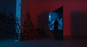 De nuit, la silhouette du Candyman, les bras en croix, se dessine en ombre, derrière un bâtiment aux formes expressionnistes, baigné dans une lumière surnaturelle bleue et rouge.