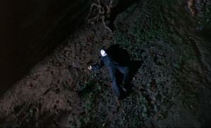 Plongée sur le corps de Michael Myers, inconscient, allongé sur l'herbe, de nuit ; plan issu du film Halloween 1978 pour notre analyse du slasher 2022.