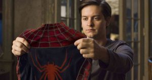 Tobey Maguire, pensif, observe son costume de Spiderman dans le film Sam Raimi.