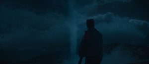 Scène de nuit dans le film Nope : Daniel Kaluuya vu de dos fait face à une tornade.