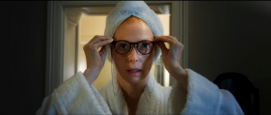 Tilda Swinton, serviette autour des cheveux et en peignoir, essaye des lunettes noires dans le film Trois Mille ans à t'attendre.