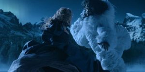 Léa Seydoux en princesse se tourne vers l'imposante bête face à elle, ressemblant à un fauve et portant un manteau blanc, sous un ciel de nuit ; plan issu du film La belle et la bête de Christophe Gans.