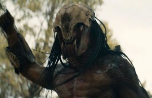 Le Predator du film Prey, avec un masque fait en squelette animal, vu en contre-plongée.