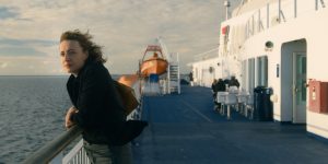Maren Eggert sur le pont d'un bateau, contre la rembarde, cheveux au vent, dans le film I'm Your Man.