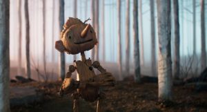 Pinocchio regarde l'horizon avec le sourire, les bras croisés, au beau millieu d'une forêt d'arbres très fins.