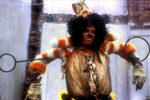 Michael Jackson déguisé en Lion peureux dans le film The Wiz, l'air affligé, il a les bras tenus écartés par une large barre de fer collée au dos, comme un prisonnier.