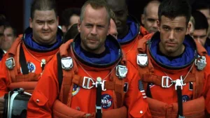 Bruce Willis, Ben Affleck et les autres astronautes en combinaison rouge attendent, assis, l'ordre de mission dans le film Armageddon de Michael Bay.