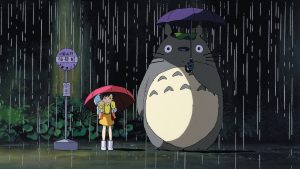 Totoro et une petite fille attendent le chat-bus sous la pluie, dans le film de Hayao Miyazaki, pour le livre sur le cinéma d'animation japonais de Nathalie Bittinger.