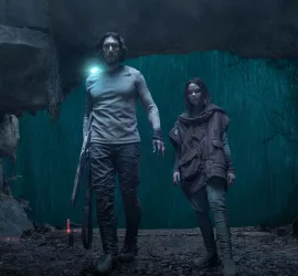Adam Driver et Ariana Greenblatt, main dans la main, entrent dans une large grotte, tandis que derrière eux, une grosse averse tombe ; plan du film 65 : la terre d'avant.