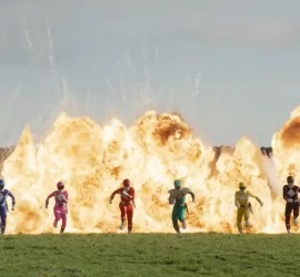 Les six héros du film Power Rangers toujours vers le futur courent devant une immense gerbe de flammes.