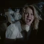 Une adolescente blonde hurle d'effroi dans une voiture cernée par ce qui semble être des zombies féminins, à l'apparence de poupées angoissantes ; scène du film Mutant.