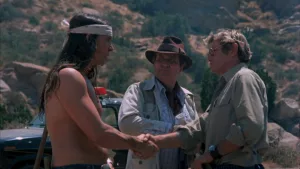 Un Amérindien torse nu et aux cheveux longs sert la main de l'acteur Larry Storch sous le regard du shériff tout près d'eux, dans le film Sweet Sixteen de Jim Sotos.