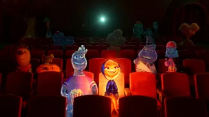 Brul, le personnage principal du film Elementaire est assise au cinéma, et brille dans la pénombre, ce qui éclaire et dérange les spectateurs derrière elle.