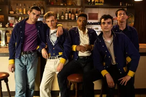 Les cinq membres de la bande des Rascals avec leur veste bleue et leur look vintage posent fièrement sur les tabourets d'un bar ; plan tourné par Jimmy Laporal-Trésor.