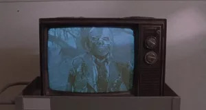Un mort-vivant squelettique apparaît sur une télévision des années 80 en noir et blanc dans le film The Video Dead.