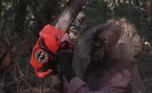Un mort-vivant squelette brandit une tronçonneuse en pleine forêt dans le film The Video Dead.