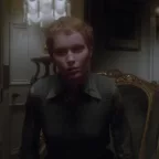 Plan rapproché-taille, issu du film Le cercle infernal, sur Mia Farrow, assise sur un vieux fauteuil dans un fauteuil sombre, qui observe en notre direction avec un regard fantomatique.