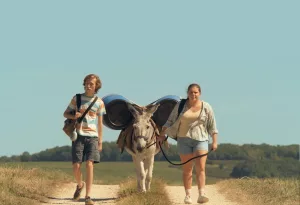 Les deux jeunes héros de Super-bourrés traînent leur âne sous un ciel bleu et un soleil de plomb, évoluant sur un sentir qui traverse une vallée plutôt verte, sous la caméra de Bastien Milheau.