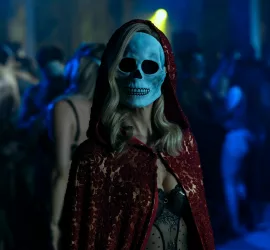 A une étrange soirée où tout le monde porte des casques de réalité virtuelle, une femme blonde porte une cape de chaperon rouge, et un masque de squelette ; scène de La chute de la maison Usher.