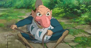 Un petit monstre est accroupi sur le sol, le sourire maléfique ; il tient un fouet et ses jambes sont très fines, semblant être de bois; son visage semble humain, mais il est pourvu d'un immense nez rose ; créature présente dans le garçon et le héron de Hayao Miyazaki.