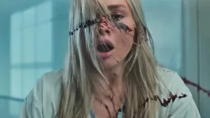 Une vétérinaire est choquée par la trace de sang qui gicle sur son visage dans le film Simetierre : aux origines du mal.