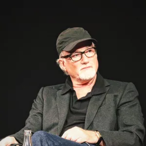 David Fincher assis lors de sa masterclass, écoutant attentivement son interlocuteur.