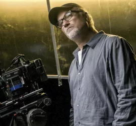 David Fincher pose à côté de sa caméra.