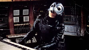 Winslow Leach, avec son casque en forme d'oiseau, joue du synthétiseur dans le film Phantom of the paradise de Brian de Palma pour le livre Bandes Originales & cinéma de genre.