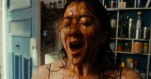 Plan rapproché-épaule sur le visage de l'actrice Shirong Wu éclaboussé par un liquide marron dans le film Sweet Juices primé au festival Court-Métrange.